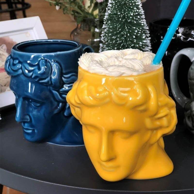 Taza de cerámica antigua con cabeza griega