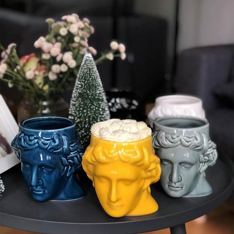 Taza de cerámica antigua con cabeza griega